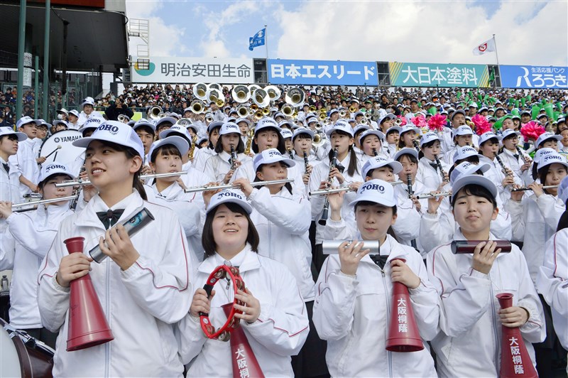 日本春季甲子園日前開打,加油團是比賽不可或缺的一環,但愛知縣東邦高校行進樂隊因出國表演無法幫球隊加油,但大阪桐蔭高校派出管樂隊相挺,管樂隊戴著東邦的帽子表演「舞蹈加油」。(檔案照片/共同社提供)
