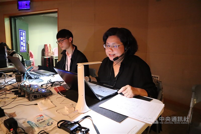 口述員趙又慈(右)坐在觀眾席後方,她正準備「直播」一場舞劇給視障朋友聽。(李先鳳攝影)