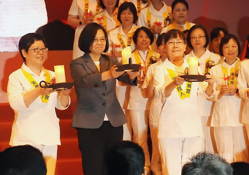 總統蔡英文（左2）8日到新北市出席108年國際護師節聯合慶祝大會，並登台參與象徵護理師薪火相傳的傳光儀式。中央社記者王鴻國攝　108年5月8日
