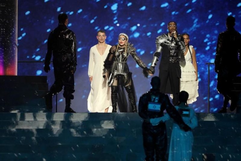 美國流行樂天后瑪丹娜（戴眼罩者）18日獻聲以色列主辦的歐洲歌唱大賽，舞者分別身穿背部綴有以色列和巴勒斯坦旗幟的服裝現身，外界認為此舉意在表達政治訴求。（路透社提供）