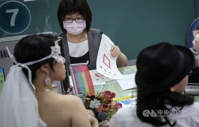 同婚登記24日開跑,上午許多同性情侶到台北市信義區戶政事務所辦理結婚登記,戶政人員在戶口名簿登記配偶資料。中央社記者裴禛攝 108年5月24日