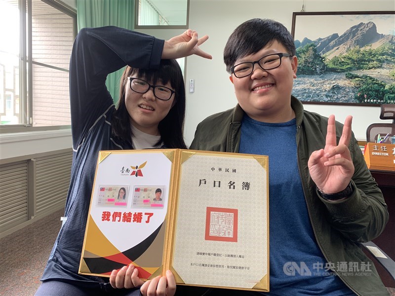 同婚登記24日上路,同性伴侶吳暐樂(左)、岩湘蓁(右)成了台南第一對完成登記的佳偶,看到身分證配偶欄有著對方的名字,兩人高興地比起「YA」的勝利手勢。中央社記者張榮祥台南攝 108年5月24日