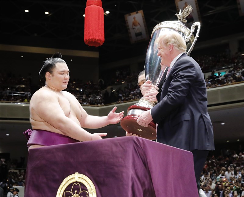 美國總統川普(右)26日在日本首相安倍晉三陪同下,觀賞大相撲比賽,並親頒「美國總統盃」大獎盃給冠軍力士朝乃山英樹(左)。(共同社提供)
