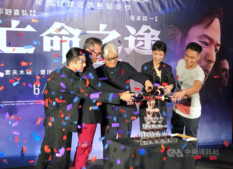 台日合製電影「亡命之途」1日晚間在台北信義威秀影城舉行首映會,為電影操刀配樂的日本配樂大師坂本龍一(中)現身,與參演台灣演員一同倒香檳塔,預祝票房長紅。中央社記者洪健倫攝 108年6月1日