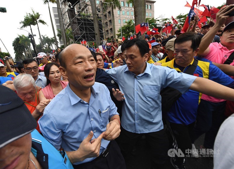 高雄市長韓國瑜(前左2)1日下午到總統府前凱道出席「決戰2020、贏回台灣」全國團結造勢大會,在護衛隊圍繞下大進場,沿途兩旁支持者熱情搖旗歡迎。中央社記者王飛華攝 108年6月1日