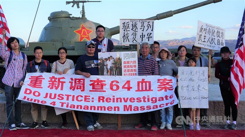 中國海外民主人士聚集在加州耶莫小鎮的自由雕塑公園,紀念六四30週年,尤姓長者(右7)陳述當年見證警察用棍棒打爆平民腦袋的場景。中央社記者林宏翰加州耶莫攝 108年6月4日