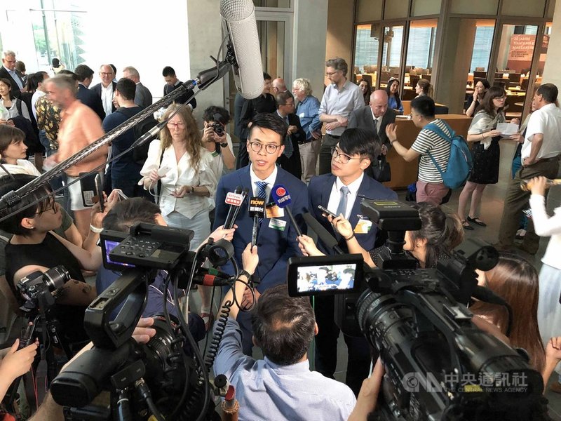 獲德國政治庇護的香港本土派人士黃台仰(前右2)和李東昇(前右1)4日在德國國會演講,吸引大批香港記者採訪。中央社記者林育立柏林攝 108年6月5日