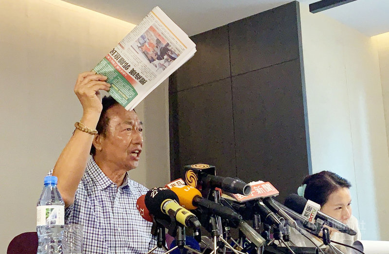 鴻海董事長郭台銘(左)10日上午召開記者會,拿出中國時報,情緒激動的表示,各大報只有中國時報今天的頭版沒有登反送中,登的卻是郭台銘與庶民經濟越來越遠,「這不是黑郭是什麼」。中央社記者葉臻攝 108年6月10日