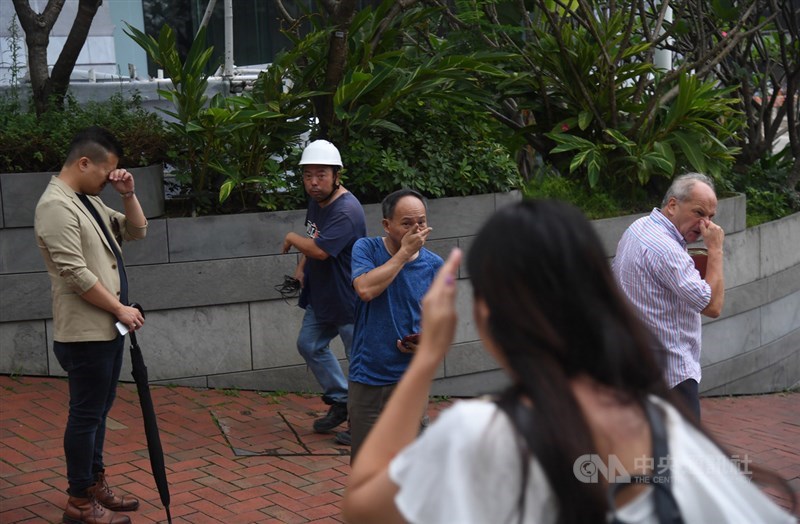 香港警方12日下午近4時施放催淚彈欲驅離聚集在立法會外並占領金鐘主要幹道的抗議民眾,讓周邊未戴護具的民眾,被薰得十分難受,紛紛捏鼻子揉眼睛。中央社記者王飛華攝 108年6月12日