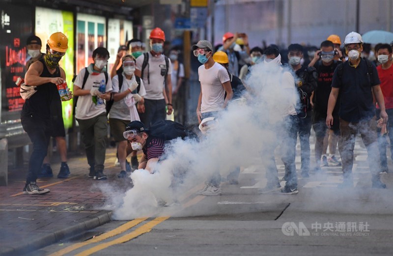香港12日因為逃犯條例修訂草案二讀,大量民眾聚集抗議,警方下午4時後陸續向民眾發射催淚彈意圖驅離,部分穿戴護具的抗議民眾想撿起催淚彈。中央社記者王飛華攝 108年6月12日