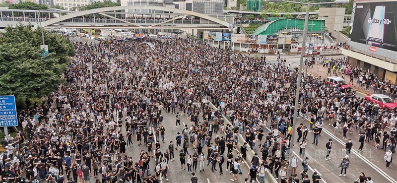 具爭議的香港逃犯條例修訂草案12日將在立法會二讀,早上有上萬名大學生前往抗議,並從立法會向外擴散到主要幹道夏愨道,重演2014年「占中」模式。許多學生戴上口罩,有備而來。中央社記者張謙香港攝 108年6月12日