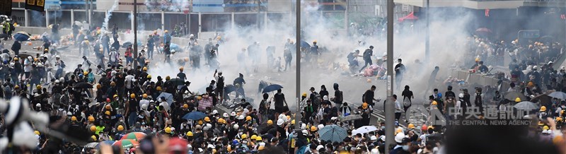 為抗議逃犯條例修訂,12日一早香港就有逾萬名年輕人聚集在立法會外並占領金鐘主要幹道;下午接近4時,香港警方在立法會、政府總部及旁邊的添華道一帶施放催淚彈,驅離部分抗議民眾。中央社記者王飛華攝 108年6月12日