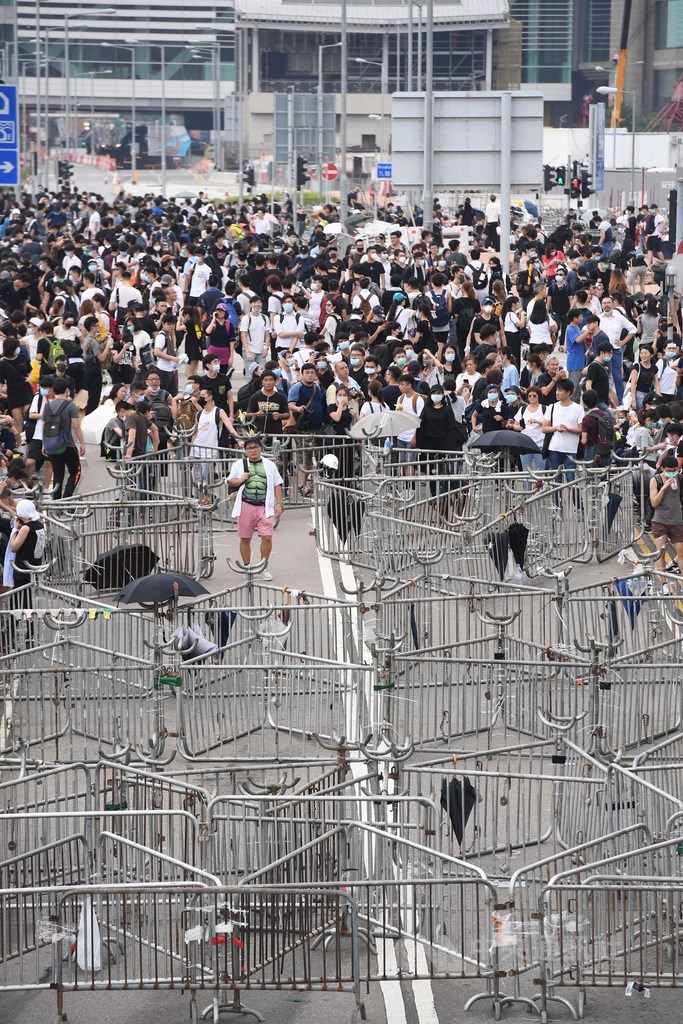 香港反送中抗議潮延燒,繼9日大遊行後,12日又有大批年輕人包圍立法會及占領主要幹道,港府在人潮外圍設置大量鐵欄拒馬,將人潮隔離開來。中央社記者王飛華攝 108年6月12日