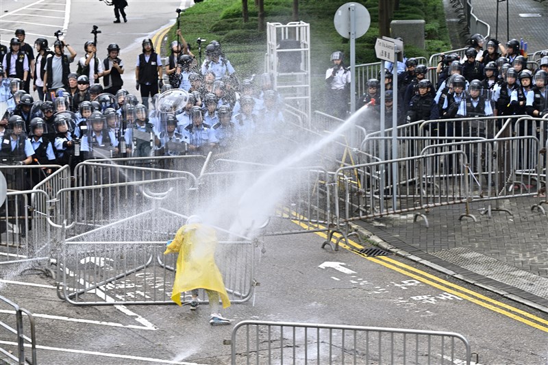 香港立法會12日恢復二讀極具爭議的逃犯條例修訂草案,數以萬計青年包圍立法會和政府總部。圖為警方以水柱驅散示威者。(共同社提供)