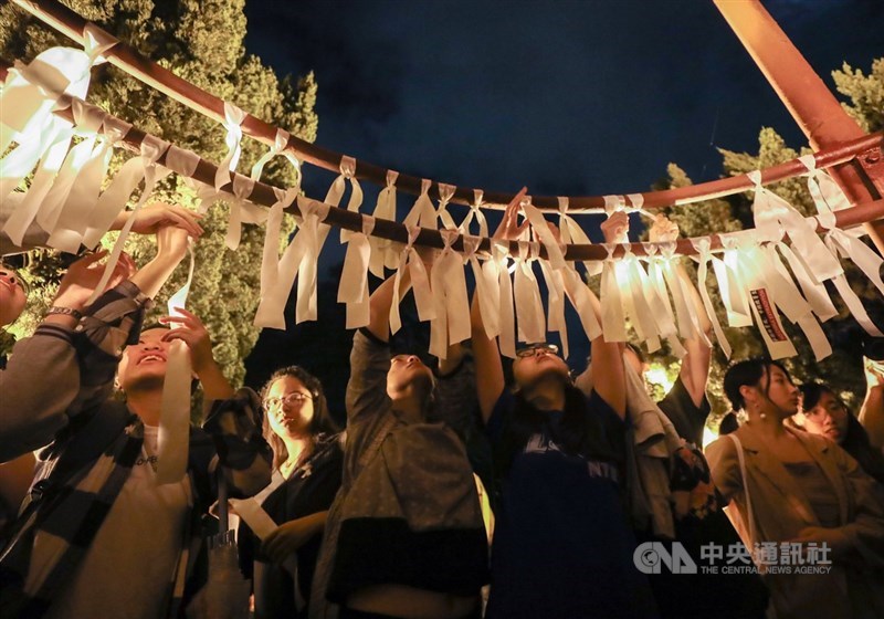 香港人民走上街頭表達「反送中」立場引發全球關注,台灣大學學生14日晚間在台大傅鐘前發起「台大撐香港-台大人反送中之夜」活動,大批學生到場聲援,並在傅鐘綁上白絲帶為香港加油。中央社記者裴禛攝 108年6月14日