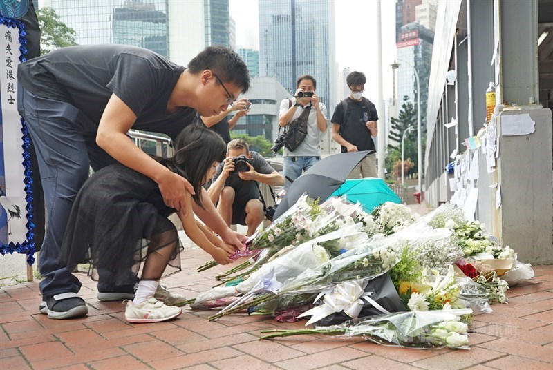 香港一名支持反對修訂逃犯條例的男子15日晚間在金鐘太古廣場高處懸掛示威橫額時,墜樓送醫不治死亡,16日上午一名家長帶著孩子到場獻花,盼亡者安息。中央社記者裴禛香港攝 108年6月16日