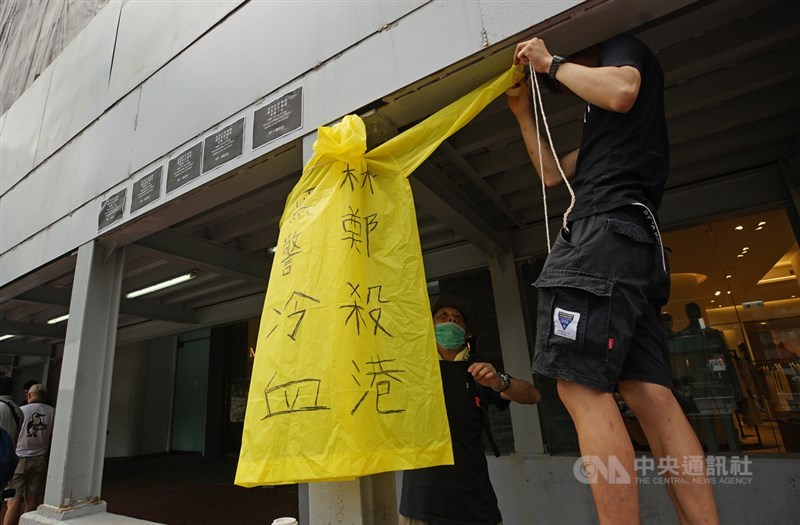 香港一名支持反對修訂逃犯條例的男子15日晚間在金鐘太古廣場高處懸掛示威橫額時,墜樓送醫不治死亡,16日上午許多民眾到場致意,有民眾在旁掛上寫有抗議標語的雨衣,表達訴求。中央社記者裴禛香港攝 108年6月16日