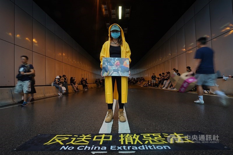 香港立法會議員17日率反修訂逃犯條例群眾至行政長官辦公室外,群眾順勢占據龍和道,一名示威者站在隧道口表訴求。中央社記者裴禛香港攝 108年6月17日