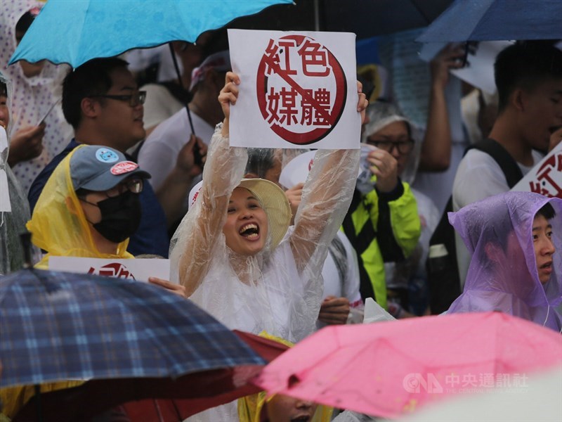 「拒絕紅色媒體、守護台灣民主」活動23日下午在凱達格蘭大道登場,許多民眾穿雨衣、撐傘到場參與,有人舉出反紅色媒體標語。中央社記者徐肇昌攝 108年6月23日