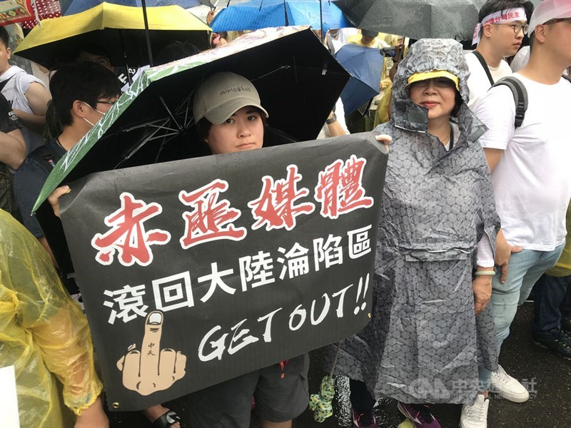 「拒絕紅色媒體、守護台灣民主」活動23日在凱達格蘭大道舉行,參與民眾舉標語表達訴求。中央社記者徐肇昌攝 108年6月23日