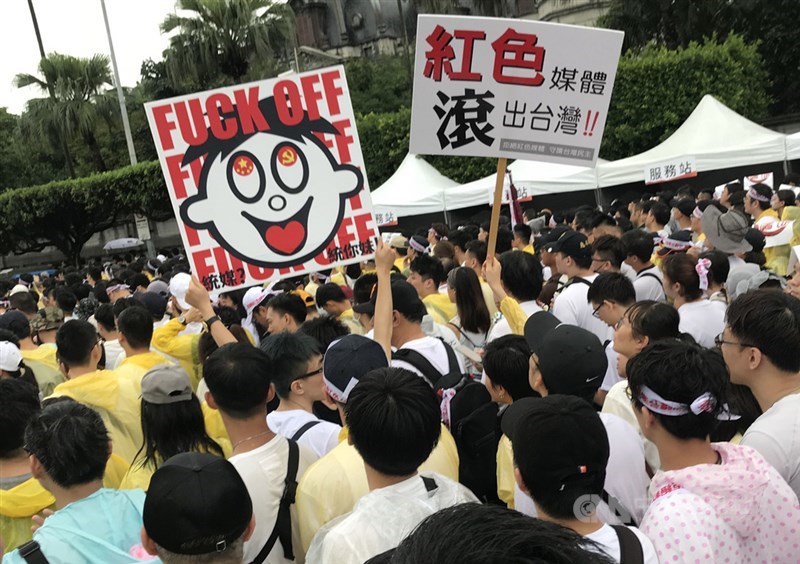 「拒絕紅色媒體、守護台灣民主」活動23日下午在總統府前凱達格蘭大道登場,參與民眾高舉反親中媒體的自創標語,表達訴求。中央社記者徐肇昌攝 108年6月23日