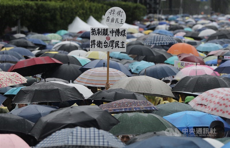 「拒絕紅色媒體、守護台灣民主」活動23日下午在凱達格蘭大道舉行,吸引大批民眾冒雨前往參加,有人高舉自製標語表達訴求。中央社記者徐肇昌攝 108年6月23日