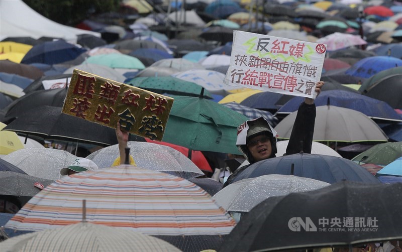 「拒絕紅色媒體、守護台灣民主」活動23日下午在總統府前凱道舉行,大批民眾穿雨衣、撐傘到場響應,有人高舉自製標語表達立場。中央社記者徐肇昌攝 108年6月23日