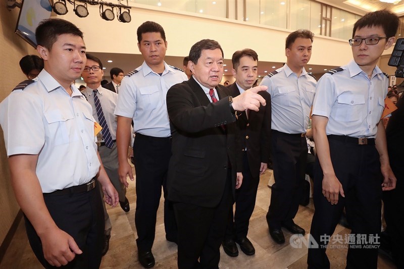 環團人士24日進入亞泥股東會場內拉布條抗議。亞泥董事長徐旭東(前左2)對股東喊話指出,要持續開會的股東請起立表達,希望入場抗議的人若要發言,會議已安排發言機會,但他不接受在會議進行時被中斷,須兼顧股東權益。中央社記者吳翊寧攝 108年6月24日