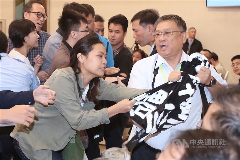 環團人士24日進入亞泥股東會場內拉布條抗議,高喊「礦場轉型.徐旭東面對」等口號,雙方發生拉扯衝突。中央社記者吳翊寧攝 108年6月24日