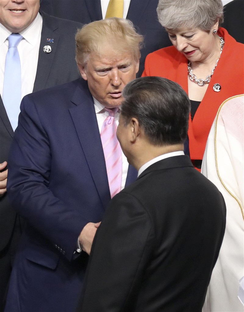 全球領袖28日齊聚日本大阪為20國集團峰會揭幕,美國總統川普(後中)和中國國家主席習近平(前)互相握手致意。(共同社提供)
