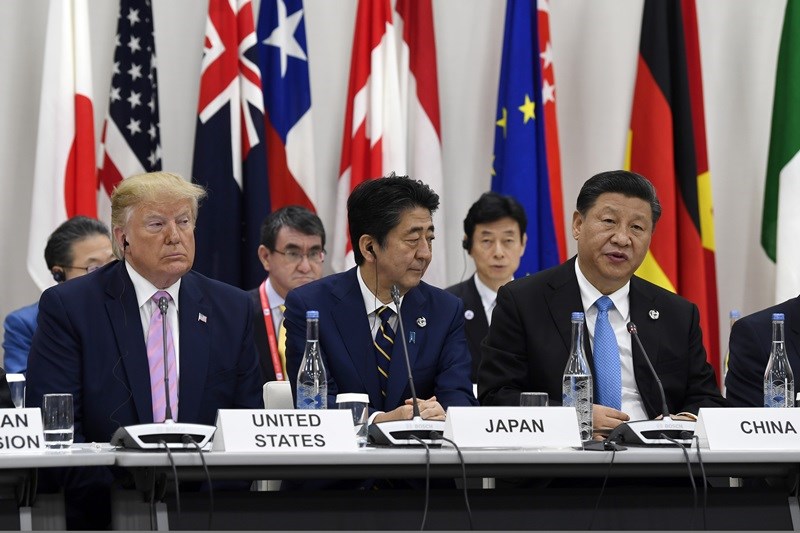 G20大阪峰會28日一場特別活動辦在一間「普通」會議室,讓美國總統川普(前左)、日本首相安倍晉三(前中)及中國領導人習近平(前右)並肩而坐。(美聯社)