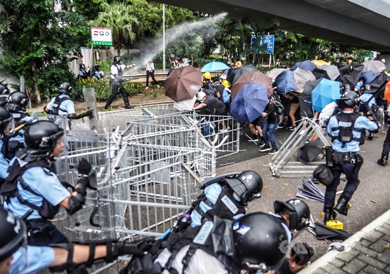 1日一早,反對港府修訂逃犯條例的示威者試圖擋住馬路,並向警方防線推進,員警則使用胡椒噴劑,阻止抗議群眾向前。中央社記者裴禛香港攝 108年7月1日