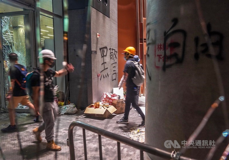 數以百計的香港示威者1日晚間撬開立法會鐵門後進一步占領議場,並將訴求寫在牆上。中央社記者裴禛香港攝 108年7月1日