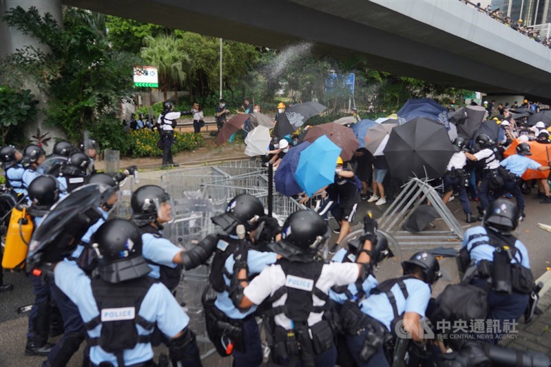香港主權移交22週年,官方預定1日早上8時舉行升旗典禮,一群反對港府修訂逃犯條例的示威者試圖擋住馬路,阻止升旗儀式進行,與警方發生衝突。中央社記者裴禛香港攝 108年7月1日