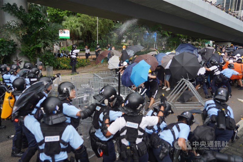 香港主權移交22週年,官方預定1日早上8時舉行升旗典禮,但一群反對港府修訂逃犯條例的示威者試圖擋住馬路,阻止升旗儀式進行,與警方發生衝突。中央社記者裴禛香港攝 108年7月1日