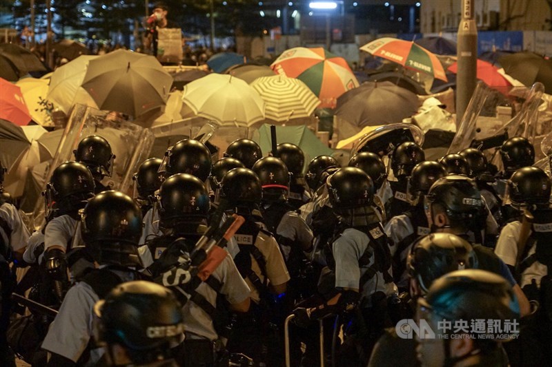 大批香港示威民眾1日晚間闖入立法會並占據議場,香港警方出動強勢警力待命驅離,2日凌晨正式行動,發射催淚瓦斯等,示威者高舉手中雨傘,全力阻擋。中央社記者裴禛香港攝 108年7月2日