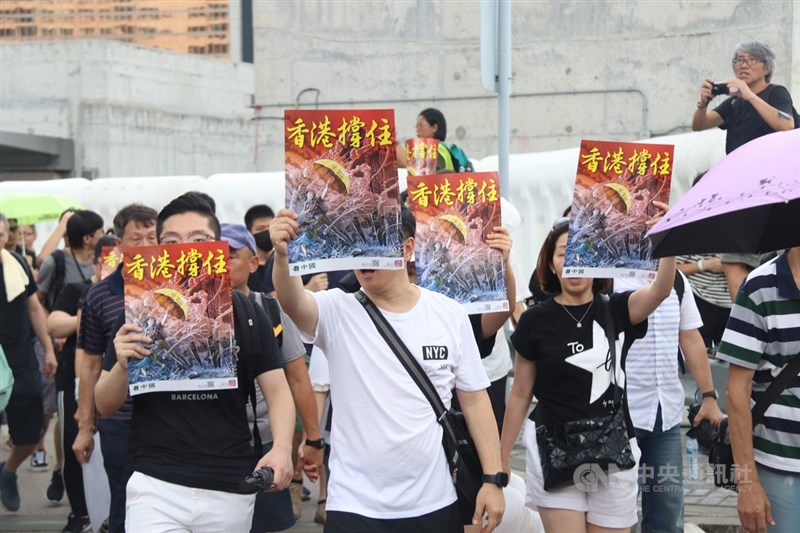 香港網民7日在九龍發起「反送中」遊行,圖為遊行人士高舉「香港撐住」標語。(中央社檔案照片)