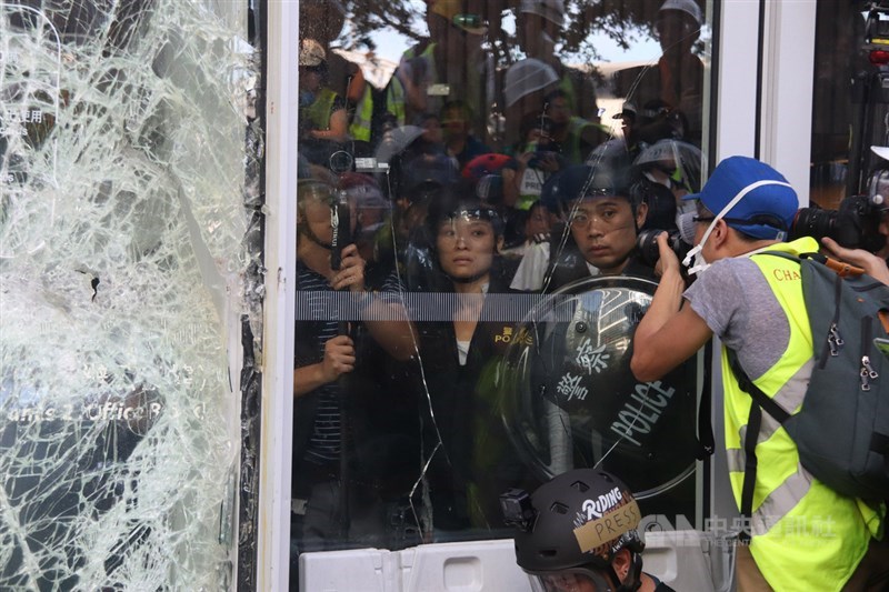 香港大批反修訂逃犯條例示威者1日衝擊立法會大樓,防暴警察在議會內戒備,但保持克制,並未衝出驅散群眾。 中央社記者張謙香港攝 108年7月1日