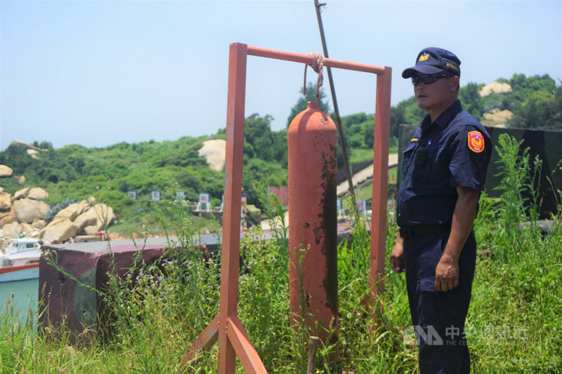 金門大膽島上駐軍每逢有船入港，就會敲鐘警示。島上派出所執勤員警潘明祥（圖）說，每天抱持觀光心情工作，樂在其中，不會「當一天和尚敲一天鐘」。中央社記者黃慧敏攝　108年7月20日