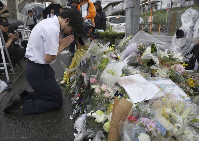 日本「京都動畫」18日上午遭人縱火,死傷慘重,民眾在事發現場附近獻花哀悼。(共同社提供)