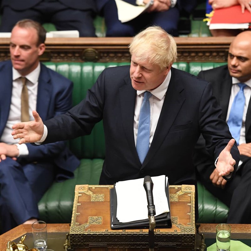 新任英國首相強生（前）25日首度對國會發言，他態度強硬表示，歐盟國家領袖應該重新考慮他們反對重談協議的立場。（圖取自facebook.com/ukparliament）