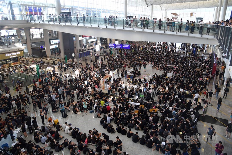 香港航空界從業員26日在在香港機場入境大廳發起集會,要求政府撤回修訂逃犯條例,並調查警方在驅散「反送中」示威者時有否濫用權力,他們身穿黑衣,在機場接機大廳劃定示威區內靜坐。中央社記者王飛華攝 108年7月26日