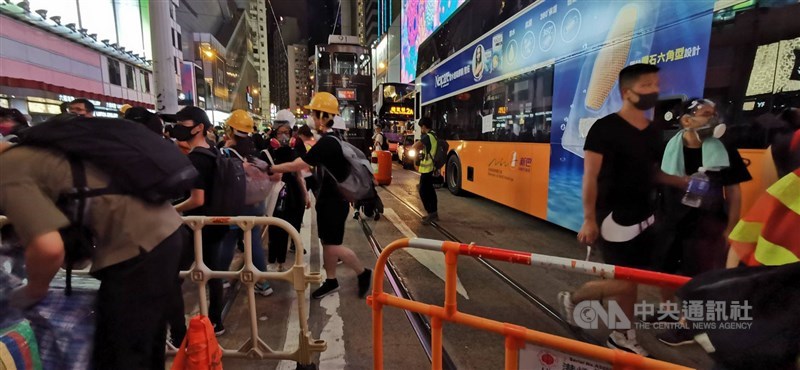 香港西環集會示威者4日晚間遭港警催淚彈驅離後，突然棄守中聯辦週邊道路，搭乘地鐵轉往東面的銅鑼灣，並在軒尼詩道築起路障。圖為銅鑼灣搭築路障現場。中央社記者張謙香港攝 108年8月4日