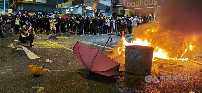 香港西環集會示威者今晚轉往銅鑼灣一帶設立新戰場,防暴警察晚間9時許進行驅離。圖為示威者在駱克道與波斯富街口焚燒木棍,意圖遲滯警方行動。中央社記者張謙香港攝 108年8月4日