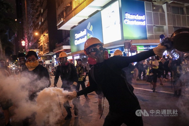 香港「反送中」運動延燒，大批民眾11日下午在維多利亞公園集會後展開遊行，港警晚間出動驅趕示威民眾，示威者反擲催淚彈。中央社記者吳家昇攝 108年8月11日