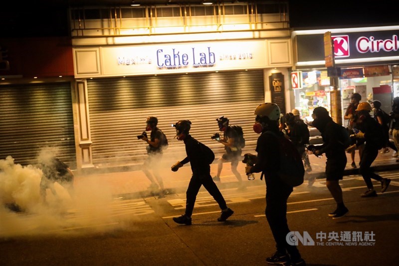 香港「反送中」運動持續不斷，示威者11日晚間占據灣仔鬧區道路，在警方以催淚彈攻勢下，慢慢往銅鑼灣方向後退。中央社記者吳家昇攝 108年8月11日