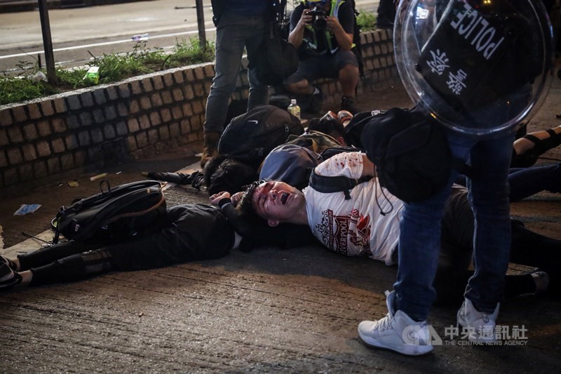 香港「反送中」警民衝突升溫,示威者11日晚間持續與港警對峙,警方在銅鑼灣以突擊方式逮捕示威者,示威者被壓制在地。中央社記者吳家昇攝 108年8月11日