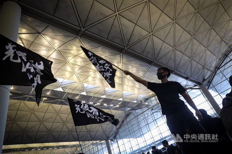 香港「反送中」抗爭持續不斷,群眾12日聚集香港機場,訴求「黑警還眼」,機場內有示威者揮舞旗幟,表達立場。 中央社記者吳家昇攝 108年8月12日