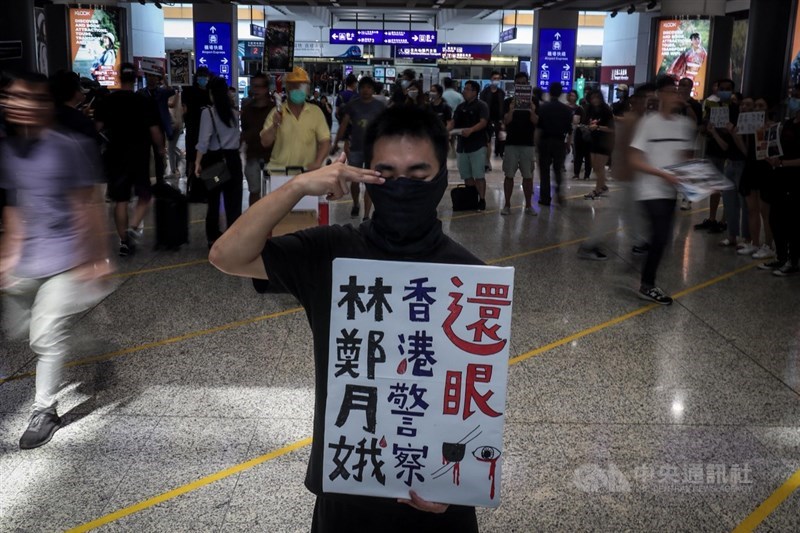 香港「反送中」警民衝突升高,一名女子11日在示威中遭警方射傷右眼,引發民眾強烈憤慨,號召百萬人12日塞爆機場,民眾以手勢及標語聲援受傷女子,要求香港警方「還眼」。(中央社檔案照片)