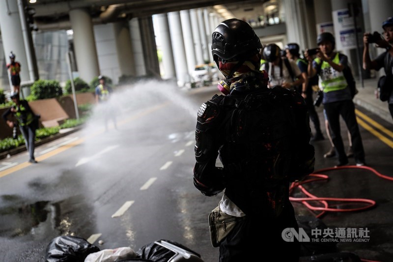 香港「反送中」運動持續延燒,大批示威者1日響應號召,堵塞機場交通,並在機場外圍進行破壞,有示威者以水槍灑水。中央社記者吳家昇攝 108年9月1日